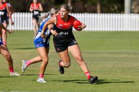 Lions player Libby Hall breaks away from her Saints opponent during Saturday's clash at Figtree Oval. Picture by Anna Warr