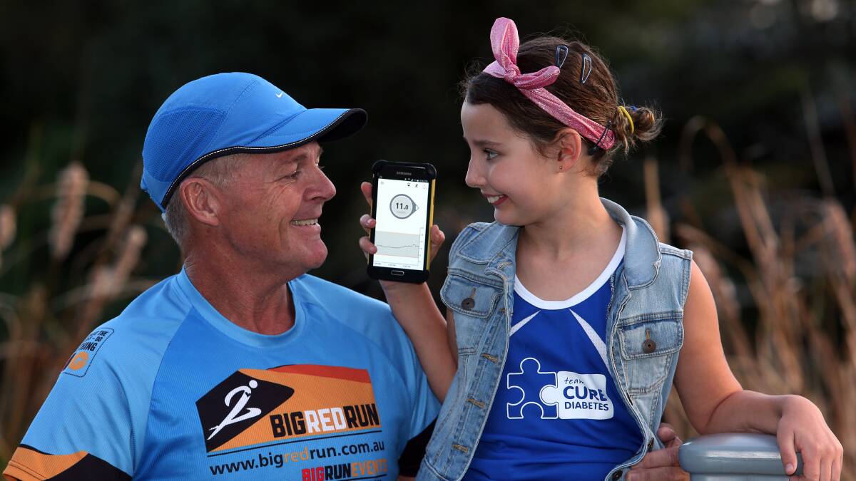 Smart technology: Balgownie schoolgirl Bella McInerney, with father Craig, can check her blood glucose levels on her smartphone thanks to a new device now funded by the federal government. Picture: Robert Peet