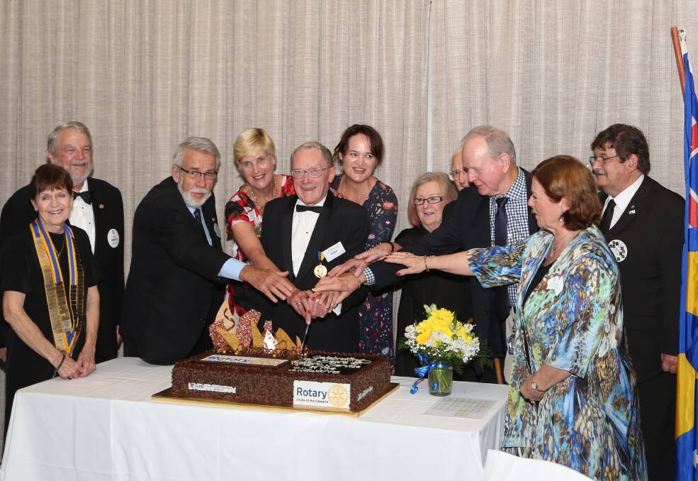 A great achievement: The presidents of Rotary clubs across the Illawarra region cut the cake to mark 90 years of service to the community.