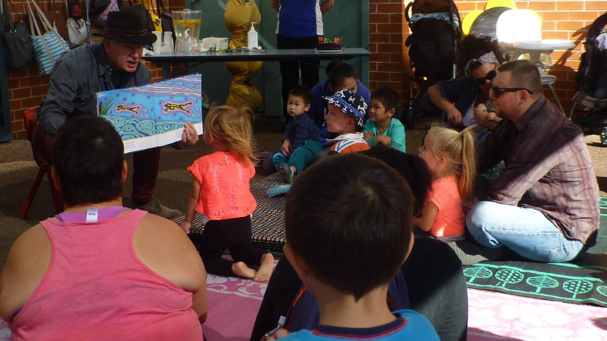 LOVE OF BOOKS: A child reads with Wollongong Lord Mayor Gordon Bradbery at Barnardos Supported Playgroup Warrawong.
