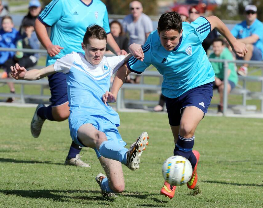 Wollongong Olympic's Blake Morgan-Monk (left) and Shellharbour's Nathan Femandez battle for possession in the u15 div 2 grand final.

