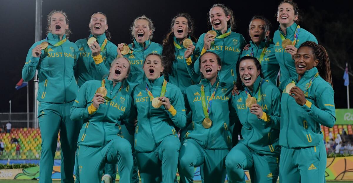 That's Gold: Nicole Beck and Emma Tonegato with the other members of the gold winning Australian Rugby Sevens team.
