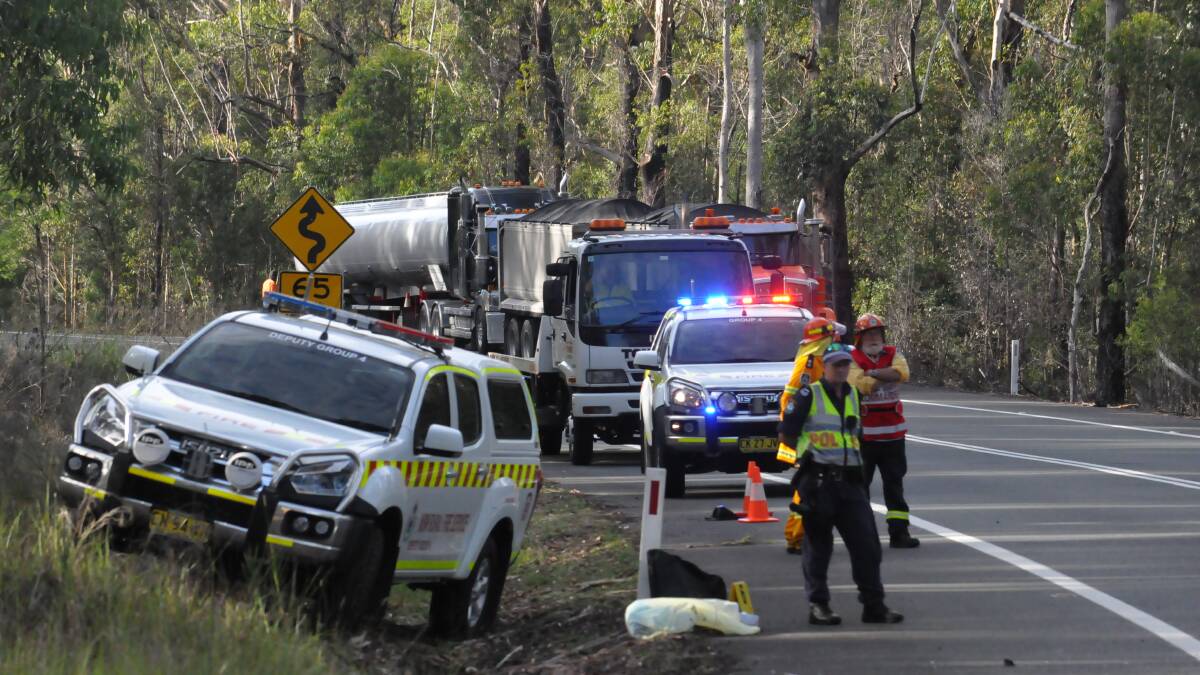 Emergency workers attend Friday's accident on the Princes Highway. They are among many people whose lives are affected by road trauma while governments bicker about funding. Photo: Damian McGill