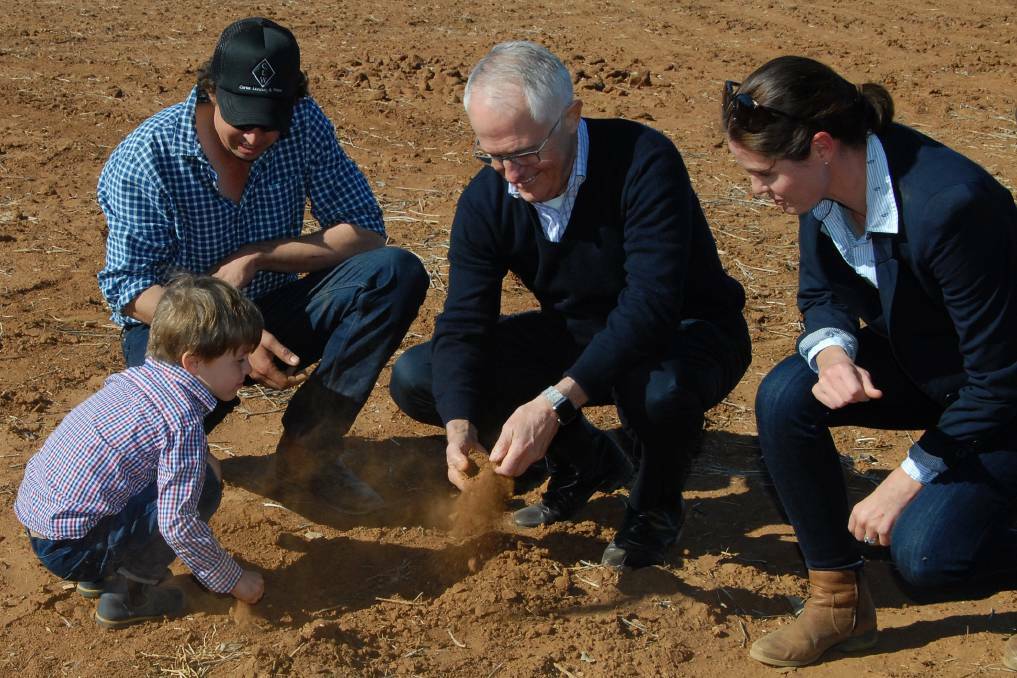 Prime Minister Malcolm Turnbull (centre) with farmer Phillip Miles (left), his wife Ashley and their son Jack (front) during a visit to Strathmore Farm in Trangie on Monday.