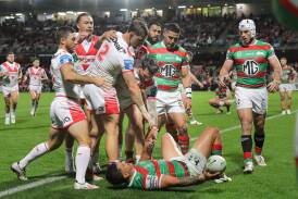 Dragon Zac Lomax offers Souths fullback Latrell Mitchell a hand up after scoring at Kogarah on Saturday. Picture by John Veage