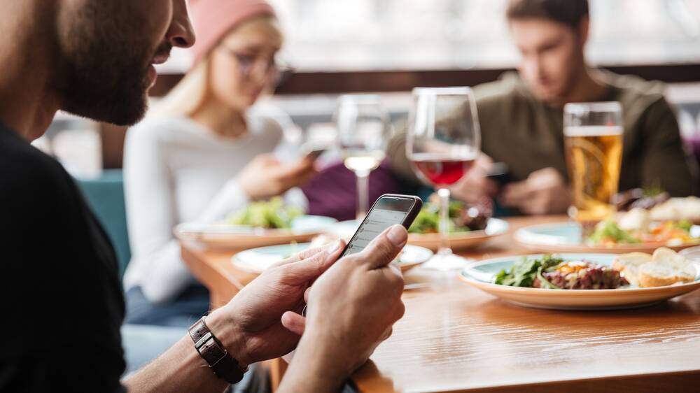 There is a growing trend of banning diners from using smart phones and tablets while in restaurants and cafes. Photo: Shutterstock