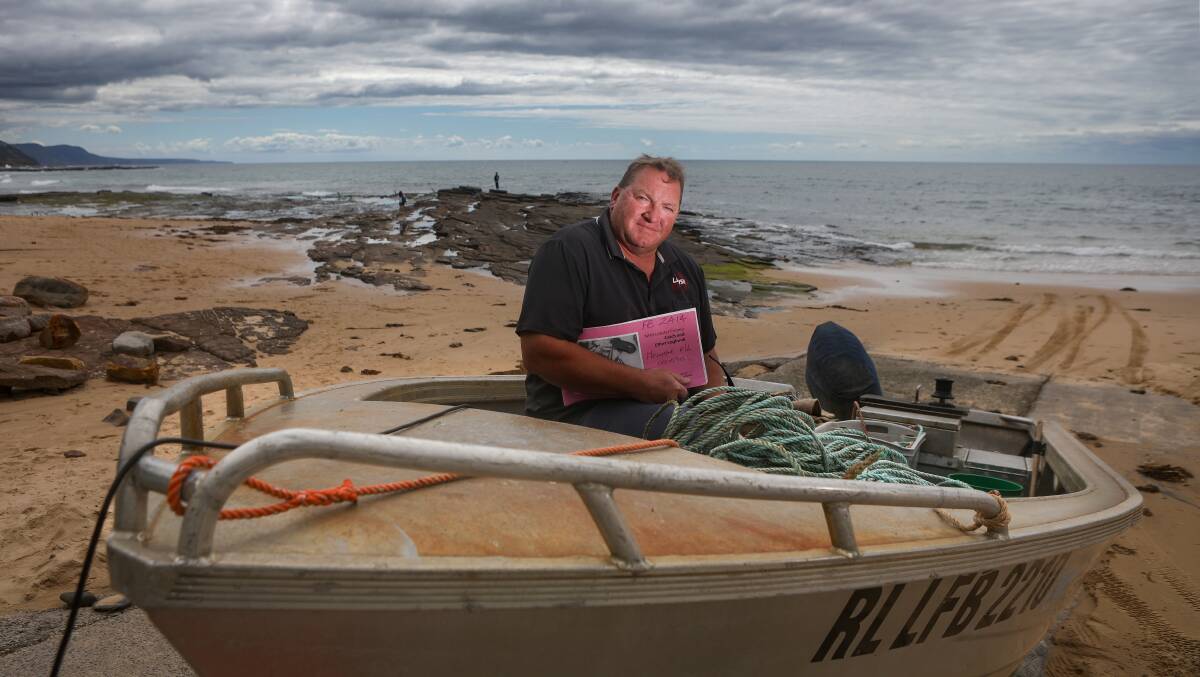 Professional lobster fisherman Mark Horne at Austinmer boat ramp with his trusty log book. Picture by Adam Mclean