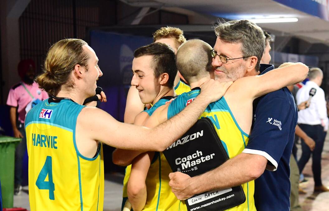 Delight: Australian players celebrate with coach Colin Batch. Picture: Hockey Australia