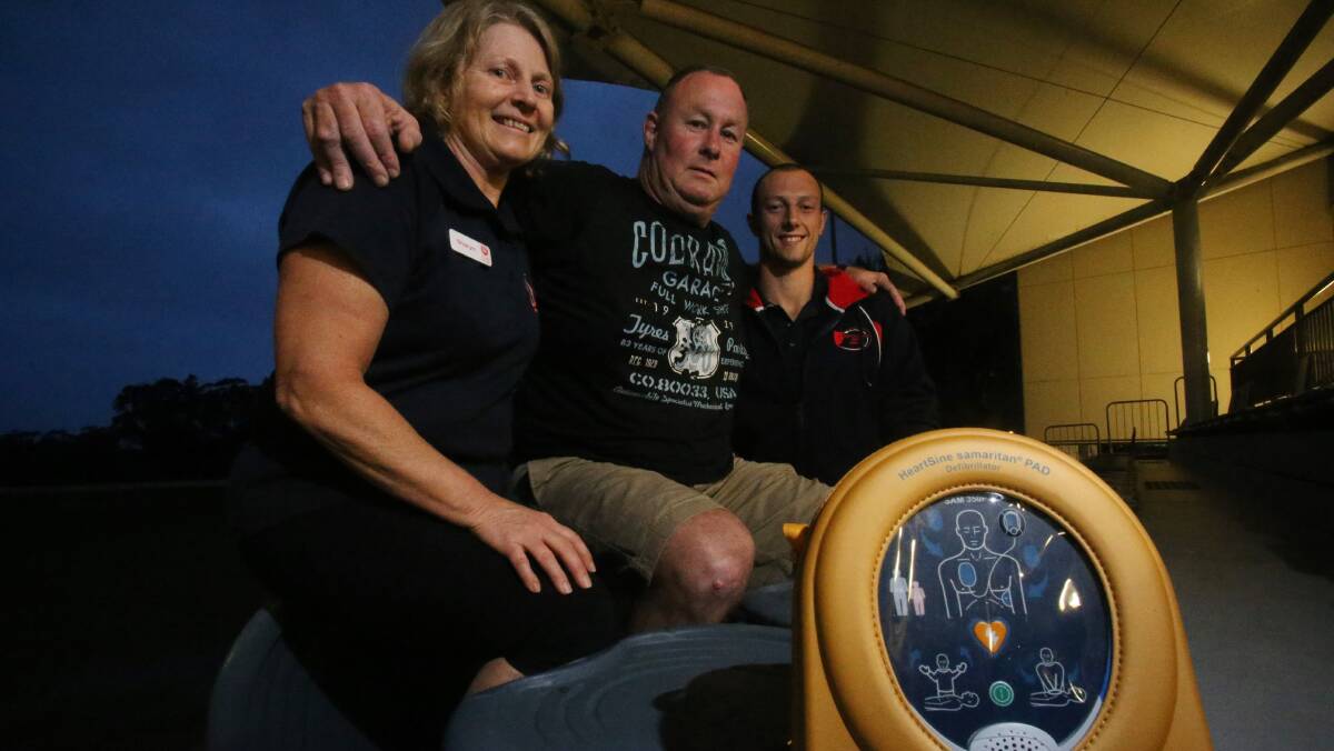 LIFESAVERS: David Reed (middle) hugs Sharyn Cahill and Joel Wilson, who used a defibrillator to save his life after he had a sudden cardiac arrest. Picture: Robert Peet