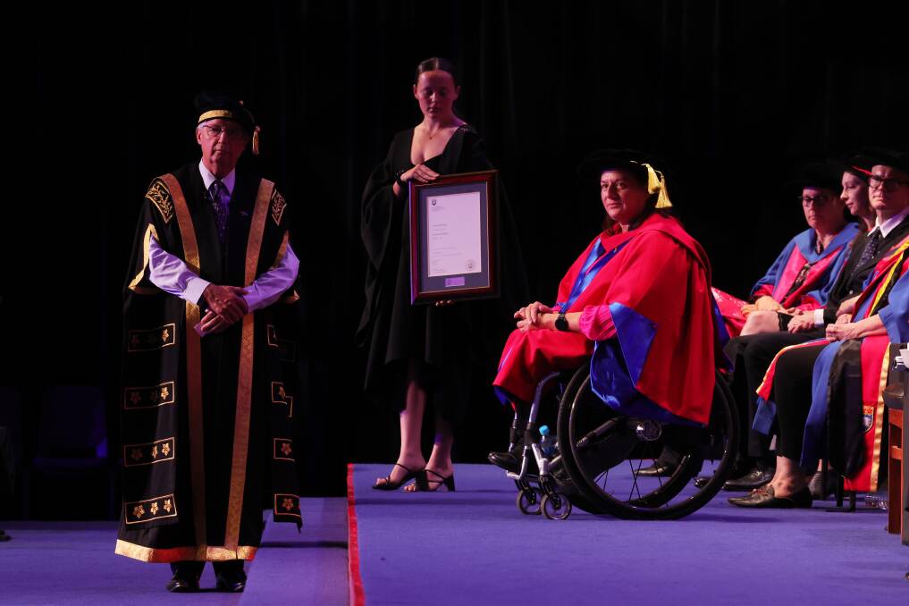 Louise Sauvage, right, about to receive her honorary doctorate. Picture by Sylvia Liber