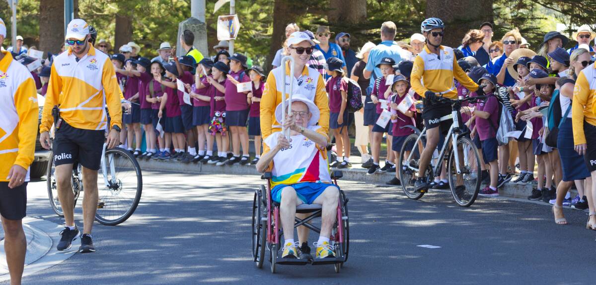 Games honour: Rotarian John Chaplin carries the Queen's Baton through the streets of Kiama on its way to the Commonwealth Games. Photo: courtesy Kiama Municipal Council