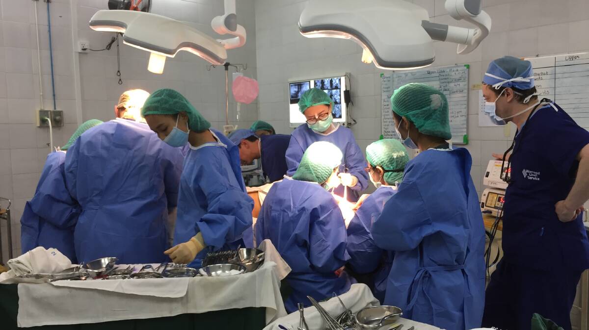Life-changing work: The Australian medical team during an operation to repair a patient's disfigurement in Yangon Hospital, Myanmar. 