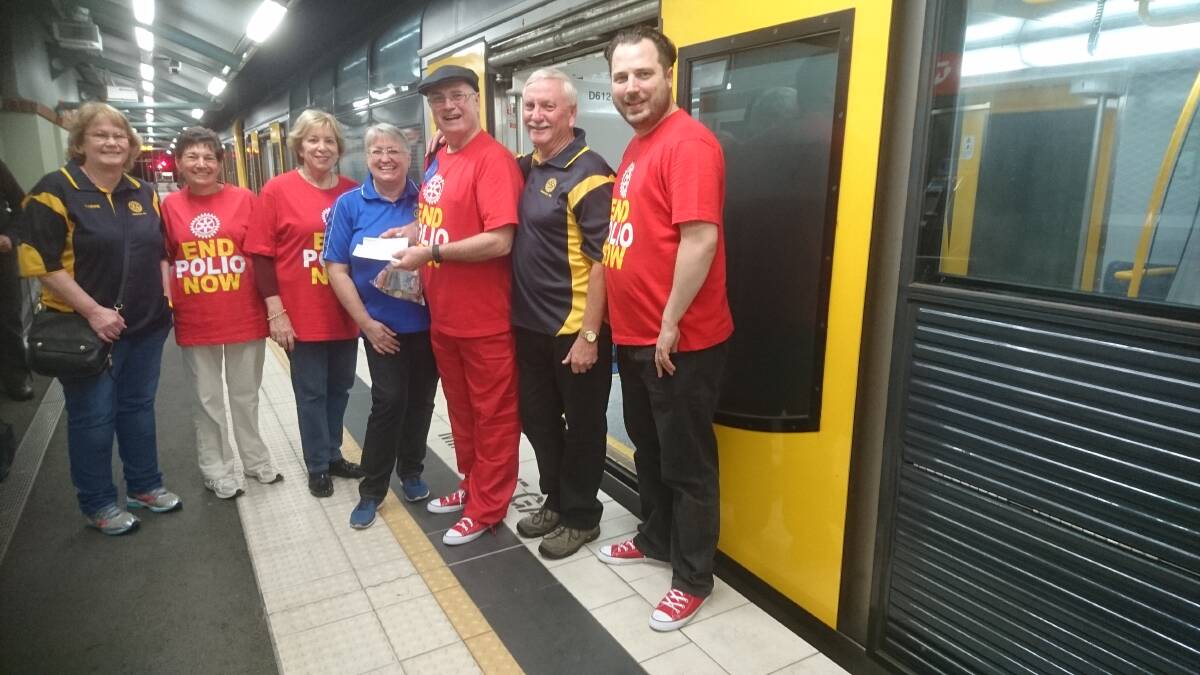 Riding the rails for a cause: Members of Illawarra-based Rotary Clubs present cheques to Mark Anderson of Rotary International (wearing cap) during his marathon journey across the entire metropolitan train network.