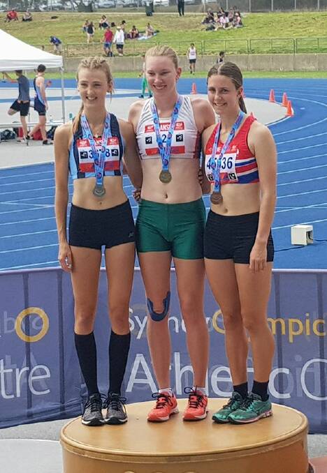 Rosie Tozer (right) with her bronze medal in the high jump.