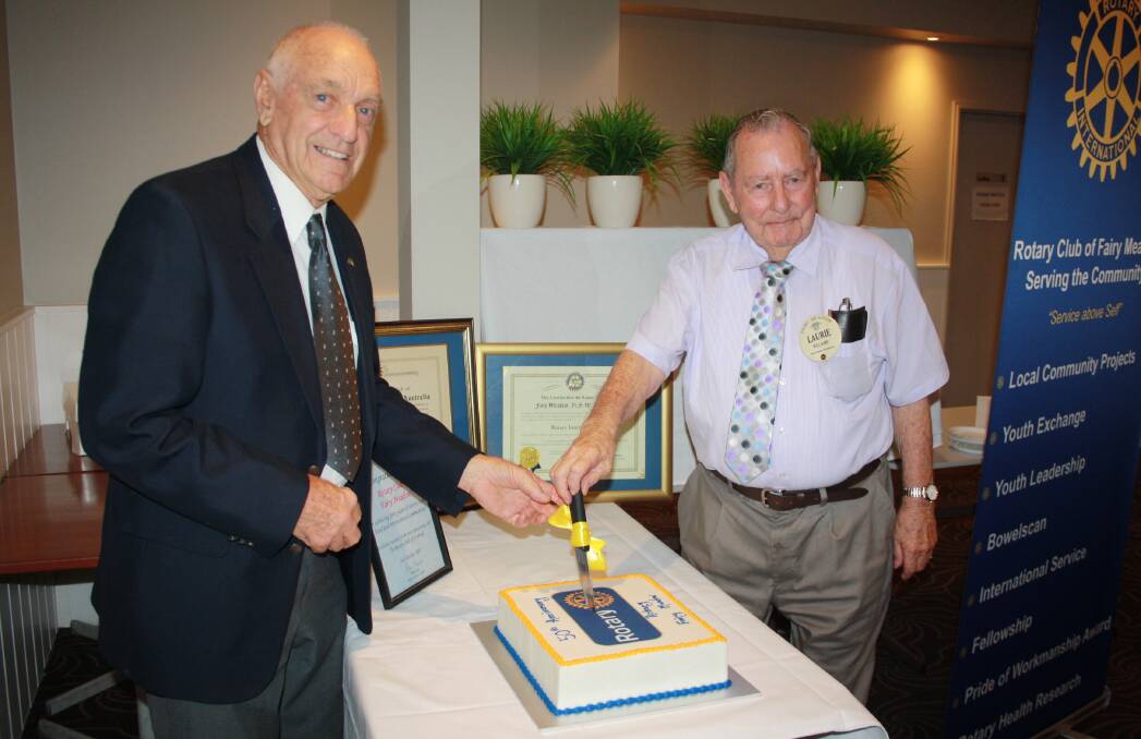 Half century: Rotary Club of Fairy Meadow charter members Keith Eshman and Laurie Williams cut the cake to mark the 50th anniversary of the club.