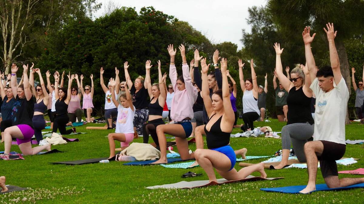 A crowd of yoga enthusiasts at Killalea Regional Park. 