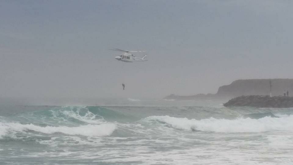 The men are winched to safety at Windang. Photo: Ross Stephenson