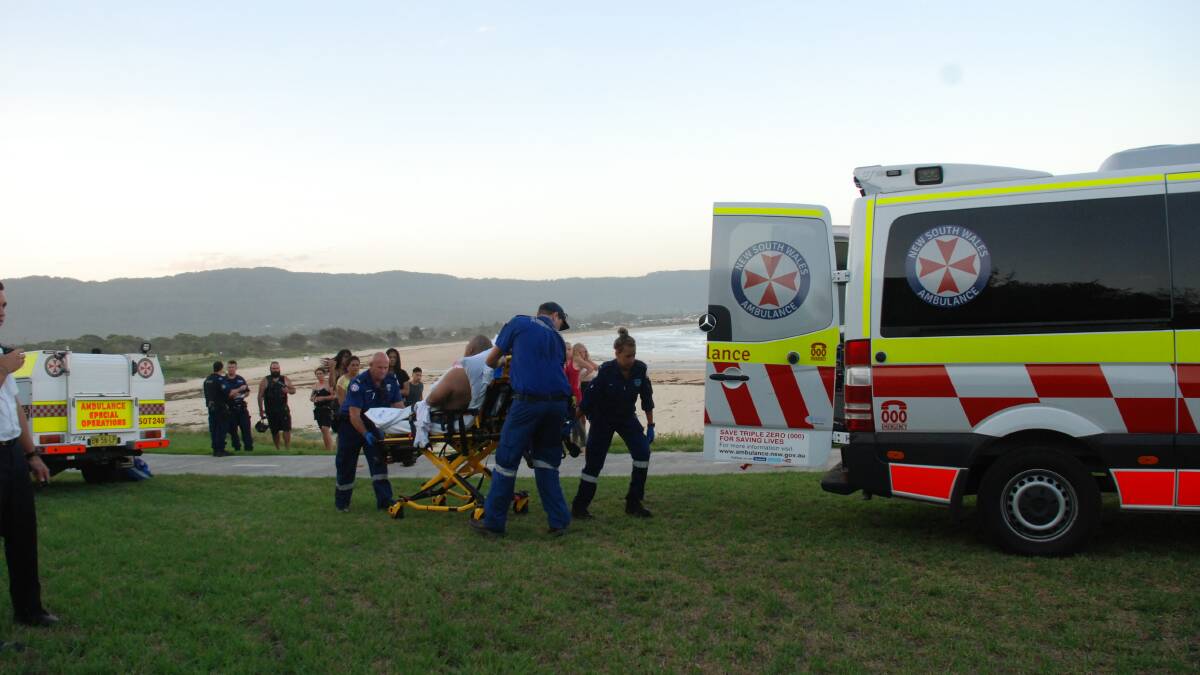 A man is treated by paramedics after getting caught in a rip at Bellambi.