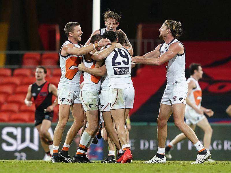 Giants players celebrate Callan Ward's goal in their four-point win over Essendon on Friday.