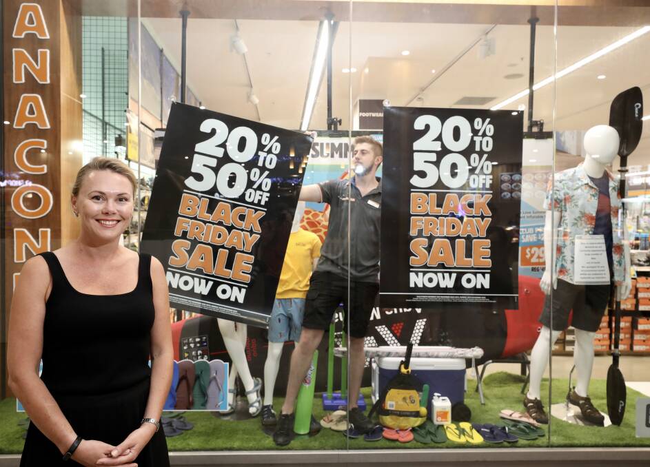 Preparations: Wollongong Central centre manager Jasmin North looks on as Anaconda assistant store manager Lachlan Mitchell positions signage for Black Friday. Picture: Adam McLean.